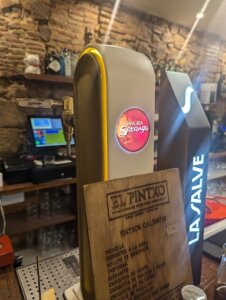 Restaurant Menu Design Psychology: Wooden menu display and drink dispenser at El Pintxo de Petritxol, showcasing a rustic and inviting dining ambiance.